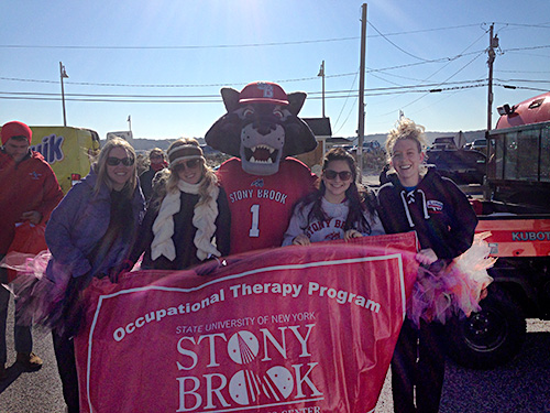 At the Polar Plunge, OT students pose with the Wolfie mascot in front of the OT banner